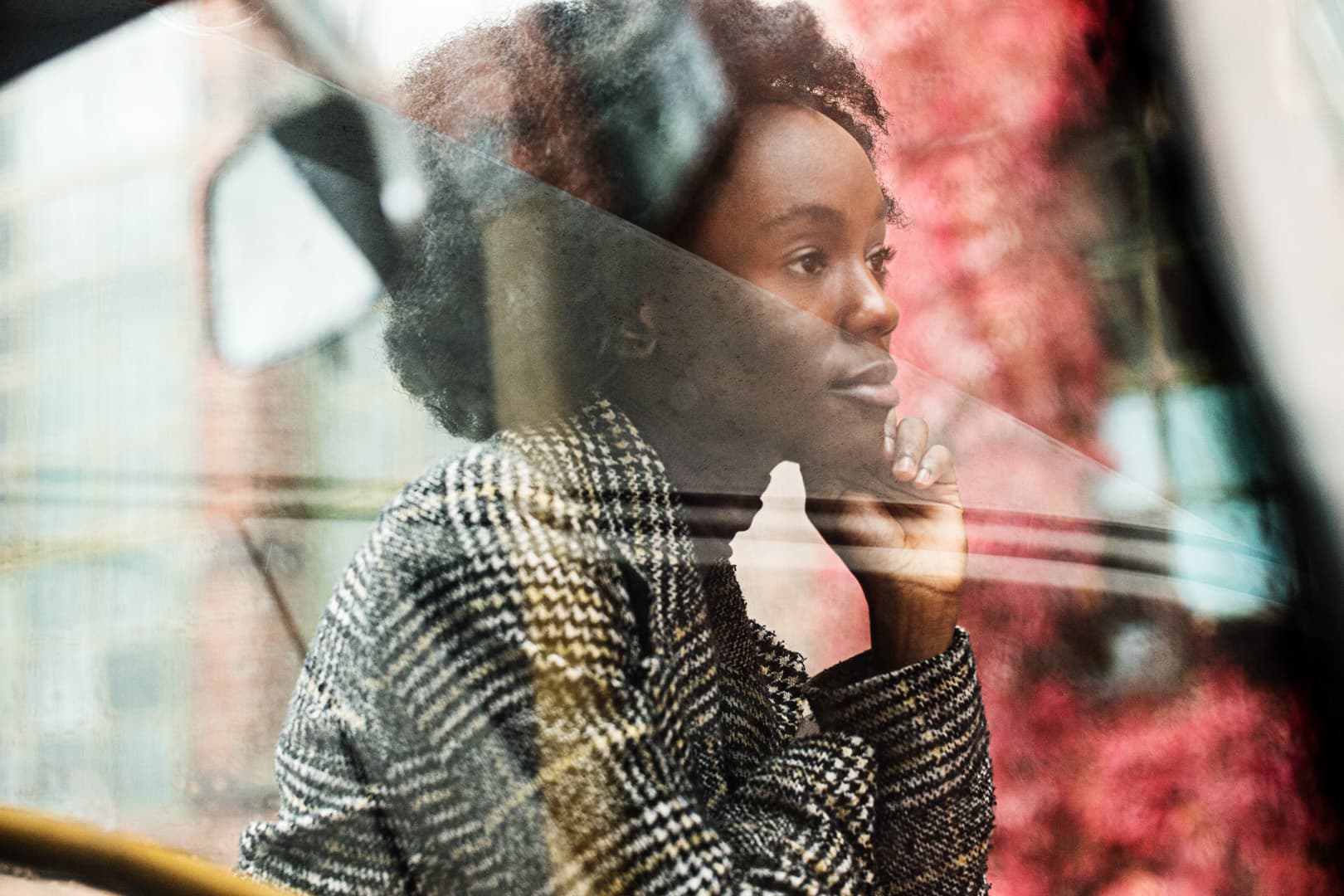 Shot through a car window depicting a young woman