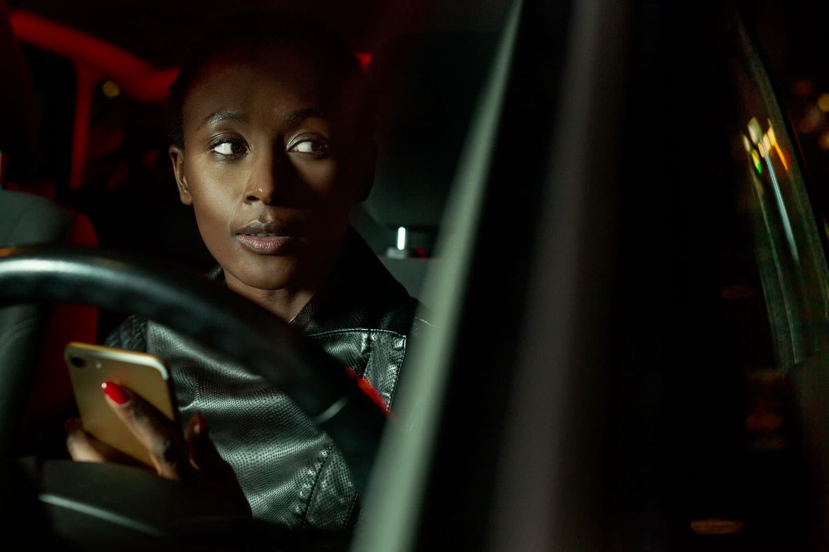 nightshot of a woman with cellphone in a car